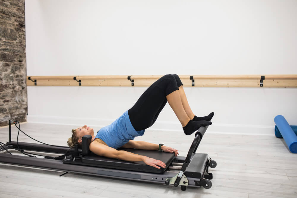 The 10 Best Pilates Studios In Calgary   Woman Exercising Reformer 1 